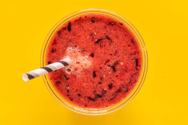 close-up macro van verse zomer koeling fruit smoothie in glas met stro - Foto, afbeelding
