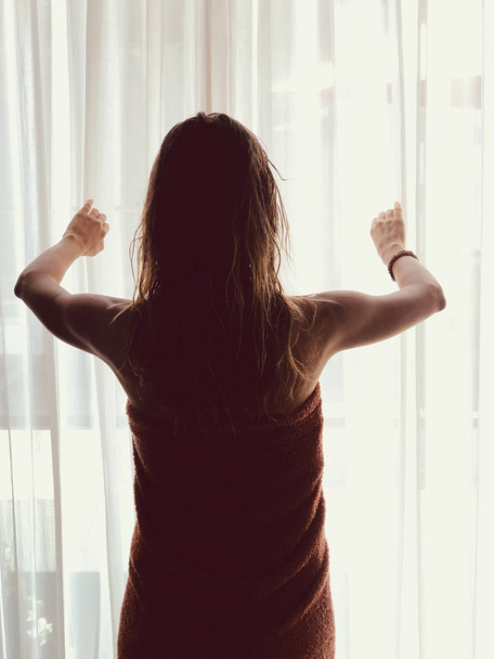 Silhouette of a girl while waking up in the room and holding cur - Фото, изображение