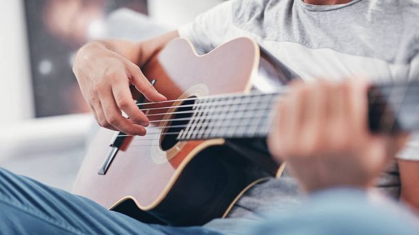 Man playing acoustic guitar in the living room. - Fotoğraf, Görsel