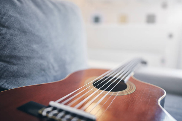 Guitarra acústica em uma sala de estar sofá / sofá
. - Foto, Imagem
