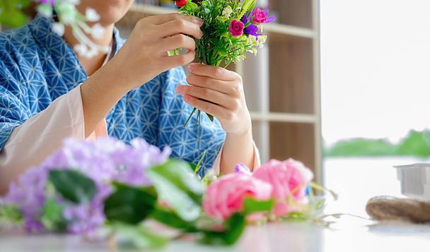 Woman hands making flower composition at florist workshop. Do it - Фото, зображення