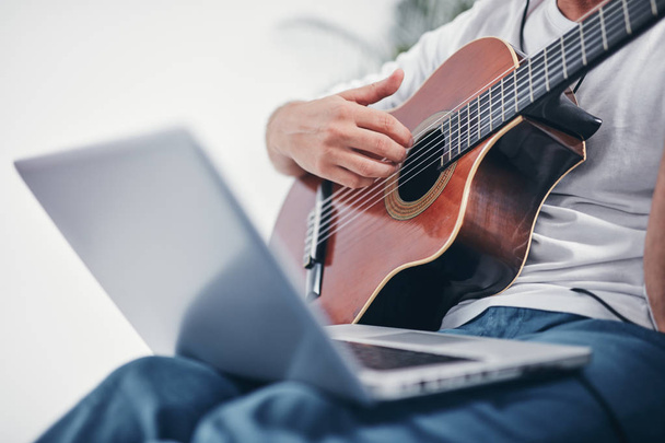 Man playing acoustic guitar in the living room. - Φωτογραφία, εικόνα