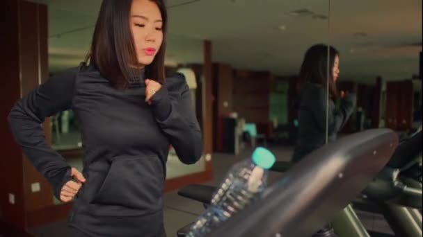 young attractive and cute Asian Korean woman doing running workout at hotel gym or fitness club jogging in treadmill training hard in healthy lifestyle and body care concept - Video