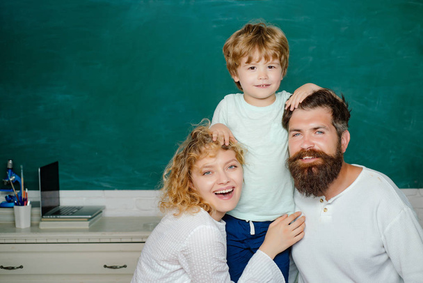 School family. Parent taking child to school. Parents feeling proud on progress of son. Funny little child with family having fun on blackboard background. School kids. - Foto, immagini