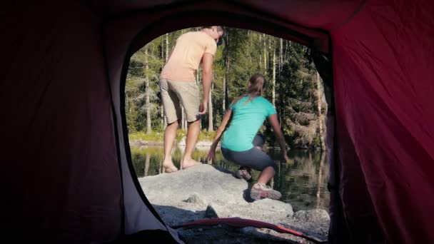muž a žena camping stan poblíž horské jezero - Záběry, video