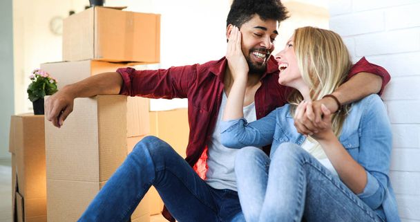 casa, la gente, el movimiento y el concepto de bienes raíces - feliz pareja divirtiéndose mientras se muda en nuevo apartamento
 - Foto, Imagen