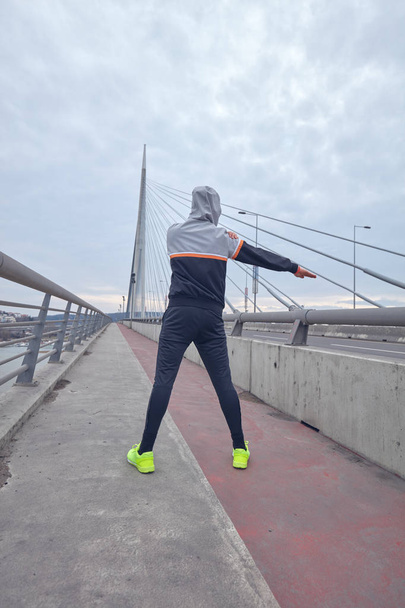Sportman trainen/joggen op een grote stad Stadsbrug. - Foto, afbeelding