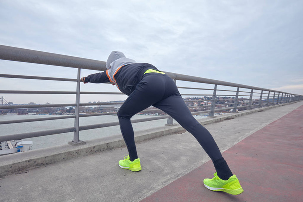 Sportsman pracy/jogging na dużym miejskim mostu miejskiego. - Zdjęcie, obraz