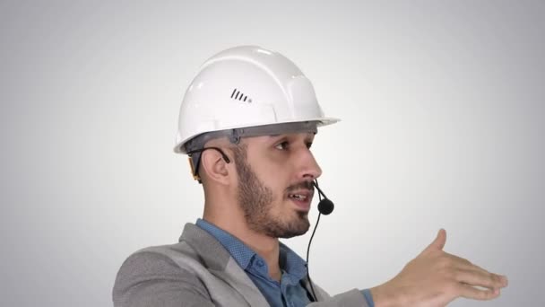 Architect inspects work of crane talking through head set, on gradient background. - Felvétel, videó