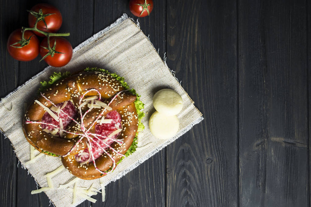 original sandwich with salami sausage and cheese on a dark wooden background - Foto, Imagen