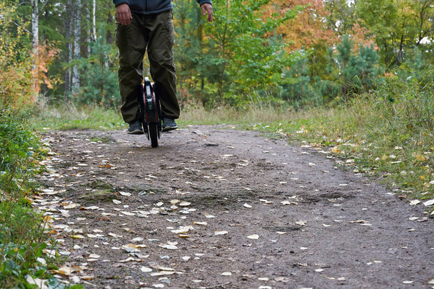 człowiek jeździ szlakiem na Monocycle. zbliżenie unicycle. - Zdjęcie, obraz