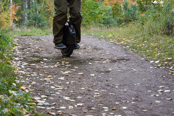 man rides down the trail on a monocycle. close up unicycle. - 写真・画像