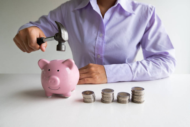 Zakenvrouw gebruikt Hammer Hide roze Piggy Bank met munten stapel, stap omhoog groeiend bedrijf naar succes en besparing voor pensioen concept - Foto, afbeelding