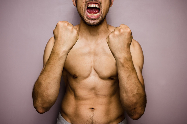 Screaming athletic male with fists raised - Fotó, kép