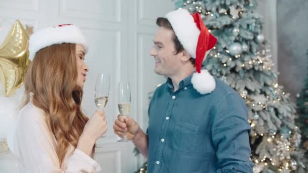 Mooie man en vrouw maken wens op Nieuwjaar nacht in Santa hoeden samen. - Video