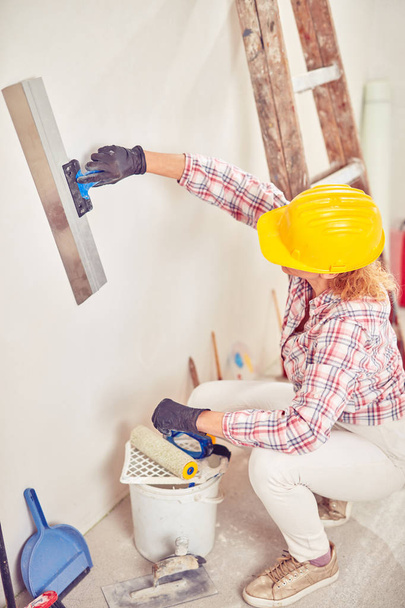 Travail femme plâtrage / peinture murs à l'intérieur de la maison
. - Photo, image