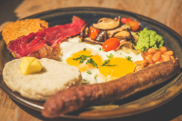 Good Ol' English Fry up Garlic and herb beef sausage with baked beans, beef bacon, cherry tomatoes, eggs, hash brown, mushy peas, mushrooms and toast - Photo, Image