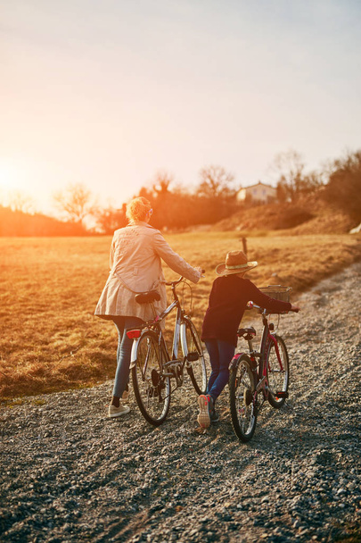 Mother and daughter with bicycles on countryside. - Photo, Image
