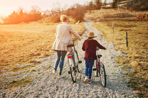 Мати і дочка з велосипедами на сільській місцевості
. - Фото, зображення