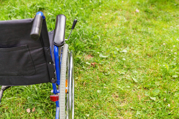 Pusty wózek inwalidzki stojący na trawie w parku szpitalnym czeka na usługi dla pacjentów - Zdjęcie, obraz