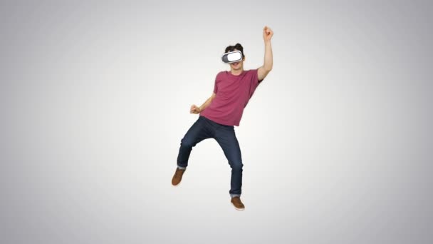 Advanced gamer in casual outfit playing dancing game in VG headset on gradient background. - Materiaali, video