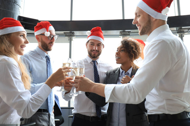 Office business coworkers celebrating winter holidays together at work and drinking champagne in office. Merry Christmas and Happy New Year. - Fotografie, Obrázek