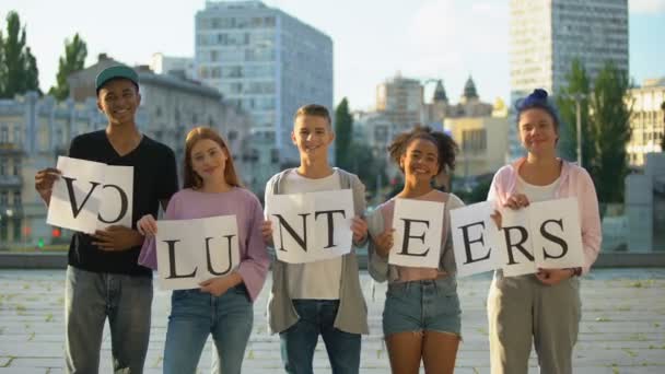 Gelukkige groep tieners houden vrijwilligers teken, sociaal project, liefdadigheid vriendelijkheid - Video