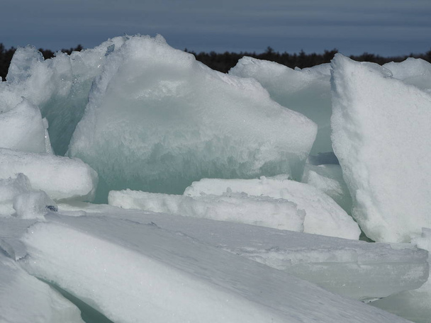 Épaisses plaques de glace gelée cassées et empilées sur la rive de la rivière des Outaouais
 - Photo, image