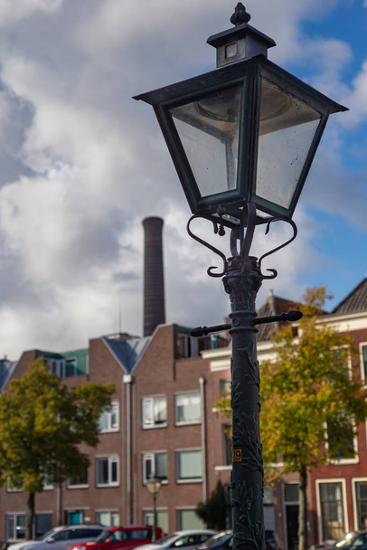Зеленый фонарный столб с дымоходом электростанции на заднем плане
 - Фото, изображение