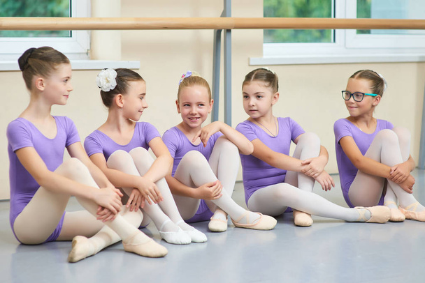 Cinque giovani ballerine sedute sul pavimento
. - Foto, immagini