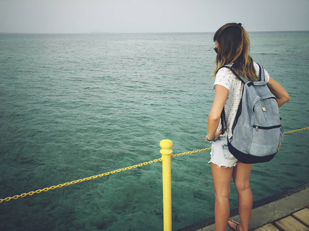 Single woman near the ocean / sea on a wooden pier. - Photo, Image
