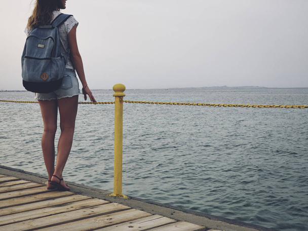 Single woman near the ocean / sea on a wooden pier. - Foto, imagen