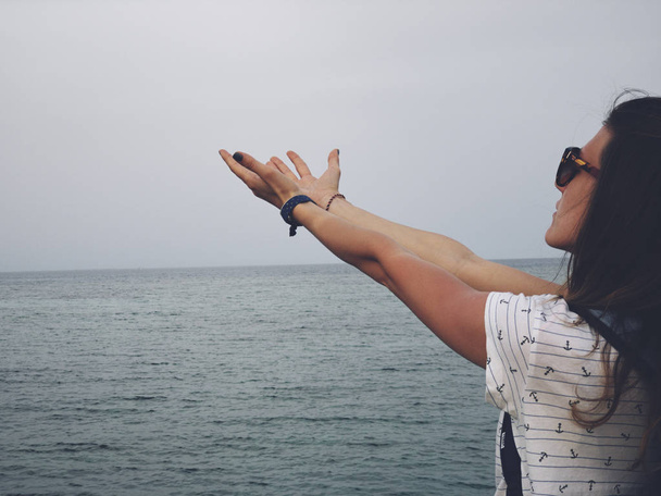 Жінка з молитовними обіймами на морському березі
. - Фото, зображення
