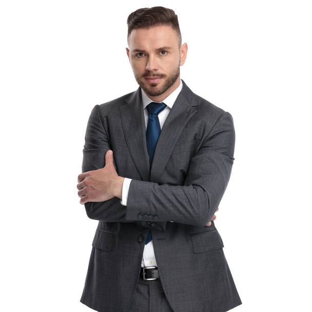 confident young businessman standing with hands crossed - Photo, Image