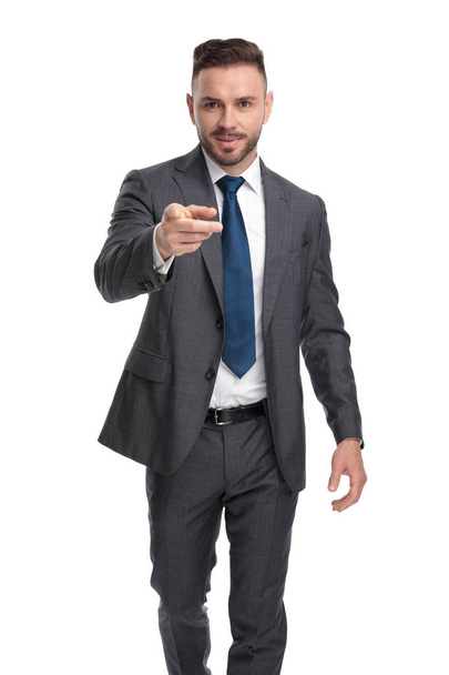Улыбающаяся молодая бизнесмен идет и показывает пальцем
 - Фото, изображение