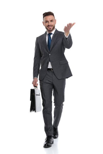 ブリーフケースを持つ幸せな若いビジネスマンは歩いて、インビチンです - 写真・画像