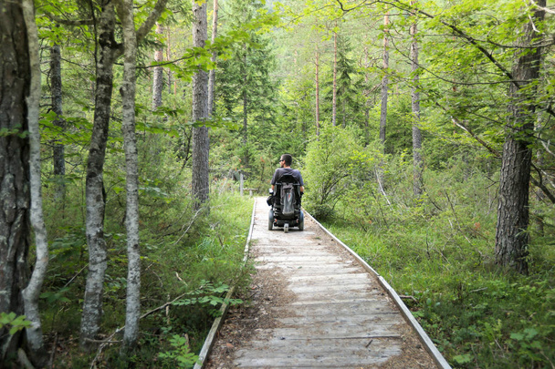 Man on a wheelchair in a forest. - Valokuva, kuva