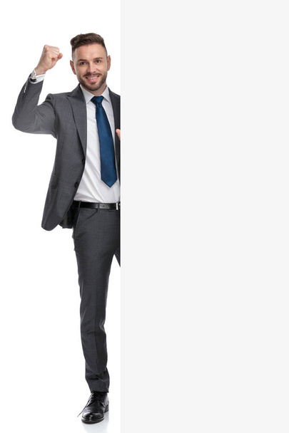 businessman celebrates success while presenting big blank billbo - Photo, image