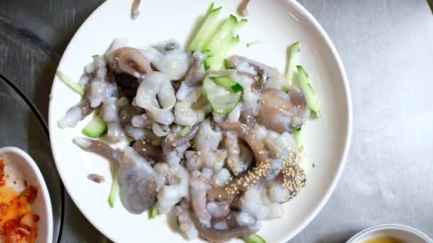 Top view korealainen ruoka (sannakji). Raakoja mustekalan lonkeroita. Valmiina syömään
 - Materiaali, video