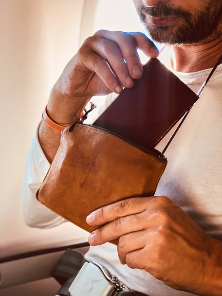 Passageiro de avião com um saco de pescoço para transporte seguro de dinheiro e d
 - Foto, Imagem