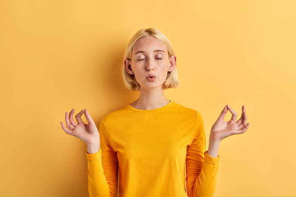attractive girl in stylish yellow jumper doing yoga, meditation - Foto, immagini