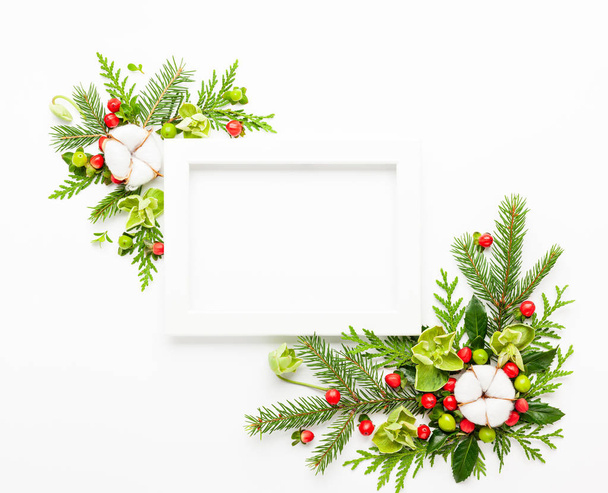 Composizione natalizia con cornice fotografica, fiore di cotone, rami
 - Foto, immagini