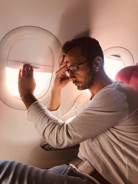 Kazanmak yanında modern bir uçak koltuğunda yorgun / hasta yolcu - Fotoğraf, Görsel