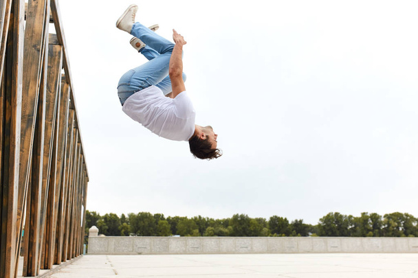 young sportsman performing back flip - Foto, imagen