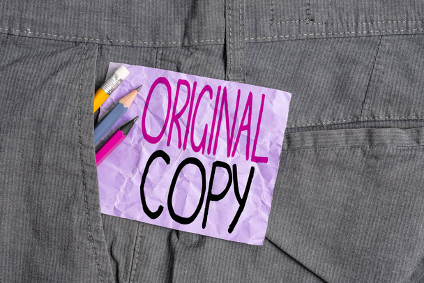 Conceptual hand writing showing Original Copy. Business photo text Main Script Unprinted Branded Patented Master List Writing equipment and purple note paper inside pocket of trousers. - Photo, Image