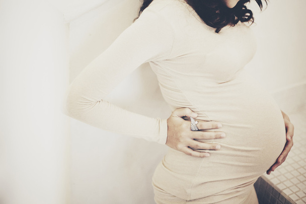 Afbeelding van zwangere vrouw aanraken van haar buik met handen - Foto, afbeelding