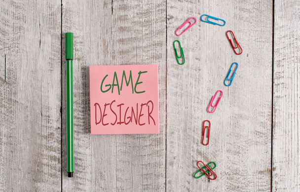 Word writing text Game Designer. Business concept for Campaigner Pixel Scripting Programmers Consoles 3D Graphics Pastel colour note paper placed next to stationary above the wooden table. - Photo, Image