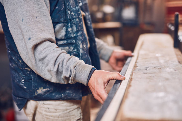 Carpintero macho trabajando en madera vieja en un taller retro vintage. - Foto, Imagen