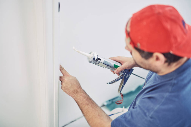 Arbeiter verwenden Silikon für Wände und Fliesen im Haus - ren - Foto, Bild