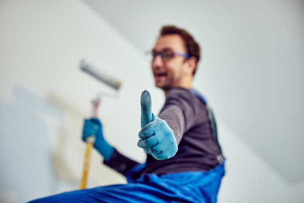 Paredes de pintura do trabalhador dentro da casa - consertos de renovação
. - Foto, Imagem